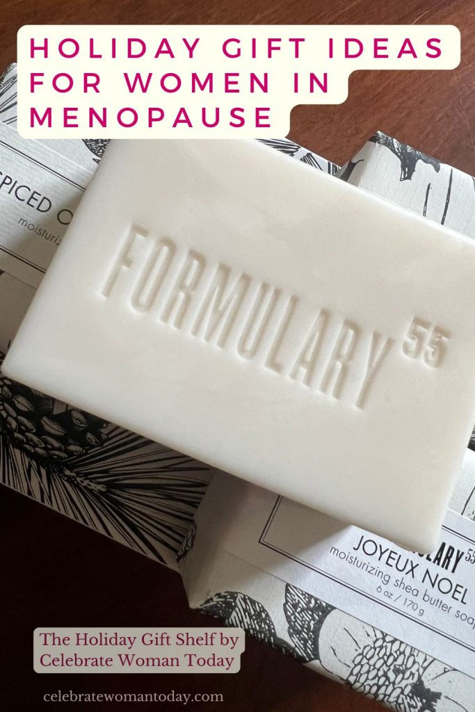Embossed shea butter soap gift bar on top of wrapped Spiced Orange and Cedar and Joyeux Noel soaps