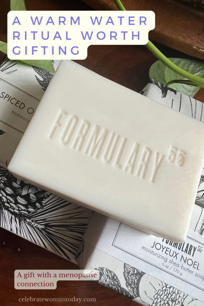 Formulary 55 soap bar with a green pothos vine and wrapped holiday soaps on a wooden table